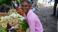 Marie Melia in Haiti with a basket of fresh vegetables she purchased with Kore Lavi vouchers.