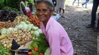 Marie Melia in Haiti with a basket of fresh vegetables she purchased with Kore Lavi vouchers.