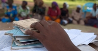 A pile of savings books sit on a table as members of a village savings group meet in Bugiri, Eastern Uganda