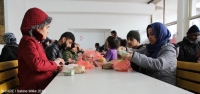 Refugees in a temporary camp in Adasevci, Serbia, prepare to eat a meal provided by CARE&rsquo;s partner organisation NSHC