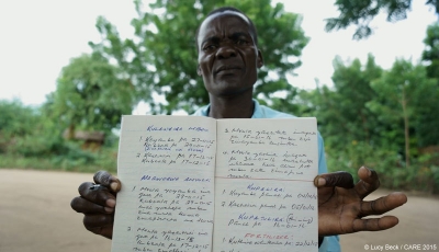 Ibrahim, a farmer in Malawi, with the rainfall record he keeps for his farmers committee