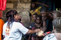 CARE staff explain anti cholera tools to a family in Sierra Leone. &copy; CARE / Tim Freccia