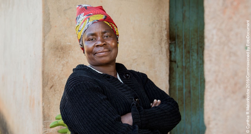 Lucia Mudima, a widow with four children, buys produce from small holder farmers in her community, ripens it, and sells it from her market stall in Harare