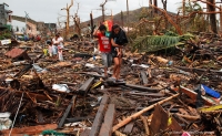 Survivors pass through an area devastaed by Typhoon Haiyan on November 12, 2013 in Leyte, Philippines.