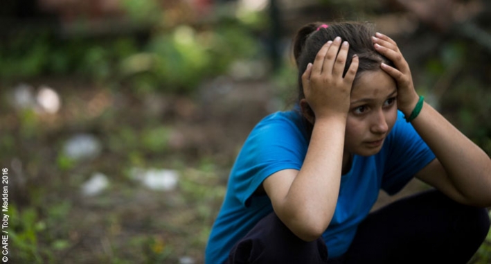 A girl holds her head at a refugee camp in Serbia, July 2016 (note: image for illustrative purposes, not necessarily an unaccompanied minor)