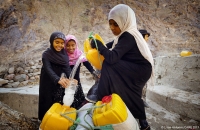 Girls pour clean water from the well in Lahj, Yemen, into their cans