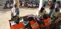 An internally displaced woman receives a kit of non-food items from CARE staff in northern Cameroon, July 2015