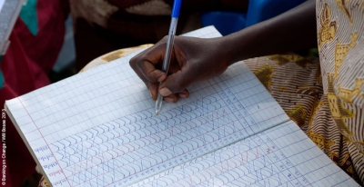 Beatrice Alowo, 43, Secretary of the Yesu Amala VSLA group in Busia District, Eastern Uganda, takes a roll-call of members before commencing a meeting