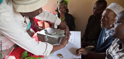 Unlocking a savings box at a meeting of the Amani Village Savings and Loan Association in Usangi village, Tanzania