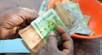 Counting money at a VSLA meeting in Uganda