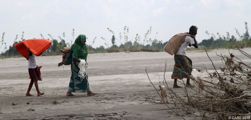 A family in Bangladesh carrying emergency aid after floods in 2016