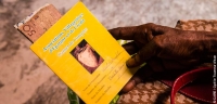 A member of a Village Savings and Loan Associations in Haiti holding her member's card