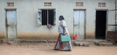 A member of the Village Savings and Loan Association in Kawete, Uganda, carrying the savings box