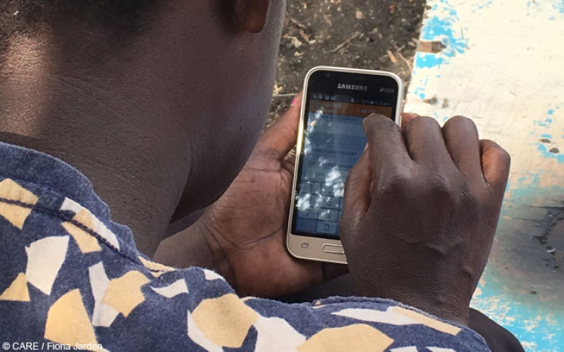 CARE VSLA member in rural western Kenya making a transaction using the Kenya Equitel mobile app