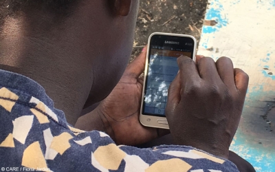 CARE VSLA member in rural western Kenya making a transaction using the Kenya Equitel mobile app