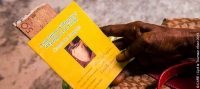 A woman holding a savings group book in Haiti