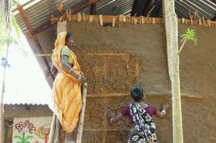 Finishing touches to the walls on a new home - built after the recent floods in Orissa, India, to withstand future floods. &copy; Philip Barritt / CARE